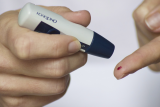 persoon met diabetes prikt in vinger om bloedwaarden te testen