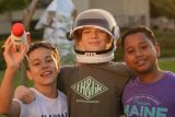 drie kinderen met een ruimtehelm en een raket in de hand