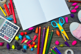 Verschillende schoolbenodigdheden: kleurpotloden, rekenmachine, schrift, schaar